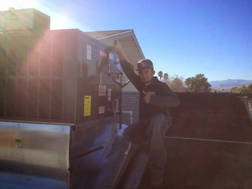 HVAC technician performing AC Tune-Up on a rooftop unit in Waipahu